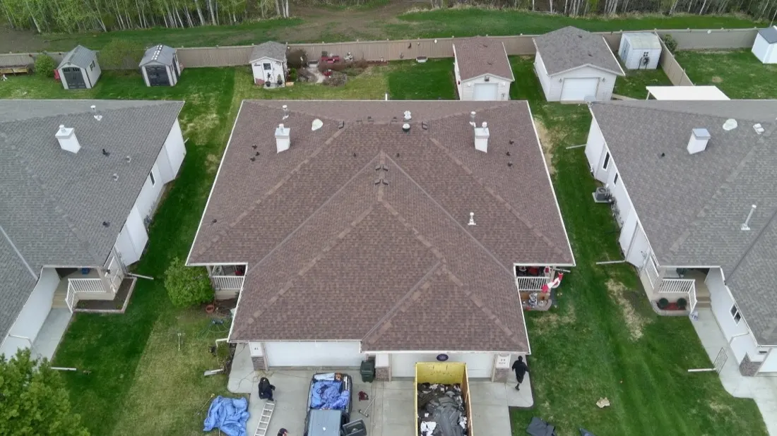 Drone view of an asphalt shingle roof on a residential home, showing the full roof surface and ridge lines